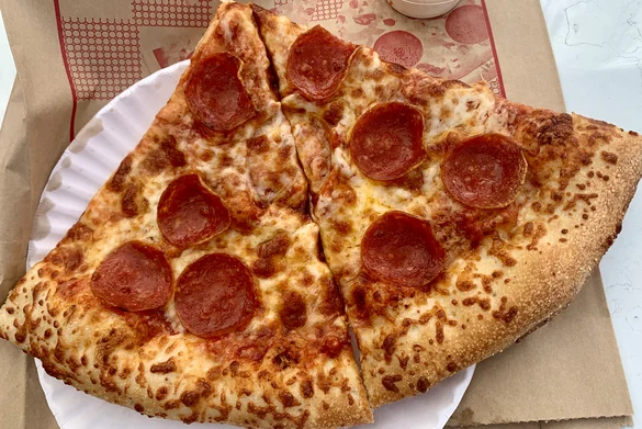 Pepperoni pizza slices on a paper plate