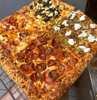 Detroit-style pizza in four sections: jalapeño popper, pepperoni, Hawaiian and veggie