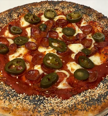 Pepperoni and jalapeño pizza with an everything bagel seasoned crust