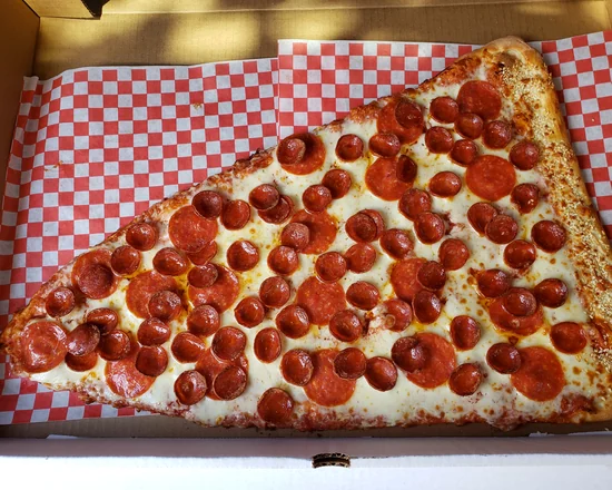 Giant 20-inch pepperoni and roni cup pizza slice with a sesame seed crust in its box