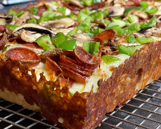 Detroit-style pizza with caramelized cheese crust, pepperoni, mushrooms and green peppers